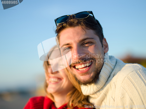 Image of couple on a beach at autumn sunny day