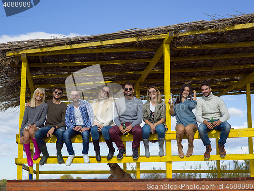 Image of Group of friends having fun on autumn day at beach