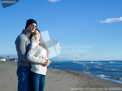 Image of Loving young couple on a beach at autumn sunny day