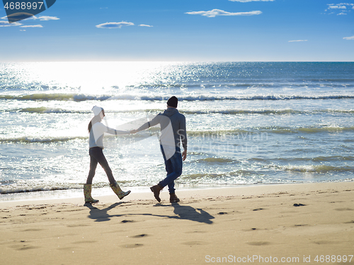 Image of Loving young couple on a beach at autumn sunny day