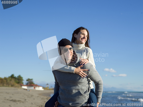 Image of couple having fun at beach during autumn