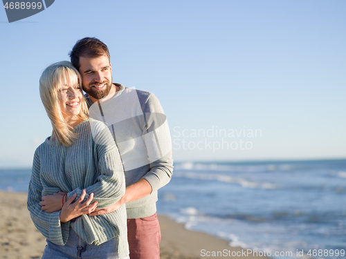 Image of Loving young couple on a beach at autumn sunny day