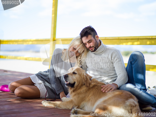 Image of Couple with dog enjoying time on beach