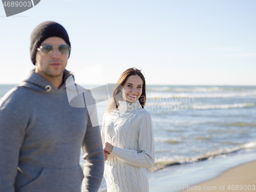 Image of Loving young couple on a beach at autumn sunny day