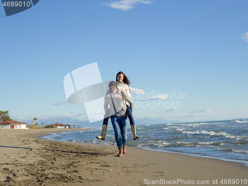 Image of couple having fun at beach during autumn