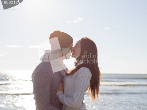 Image of Loving young couple on a beach at autumn sunny day