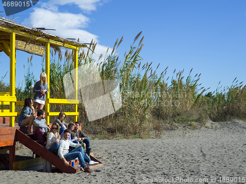 Image of Group of friends having fun on autumn day at beach