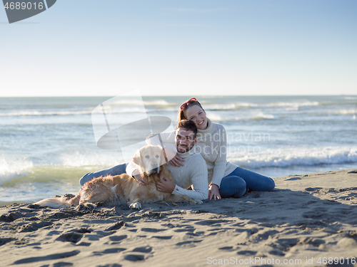 Image of Couple with dog enjoying time on beach