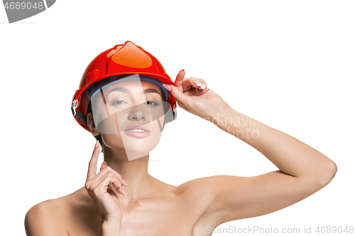 Image of Portrait of confident female worker in orange helmet