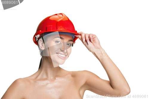 Image of Portrait of confident female worker in orange helmet