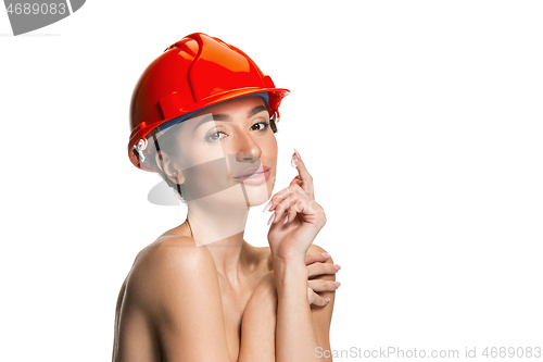 Image of Portrait of confident female worker in orange helmet