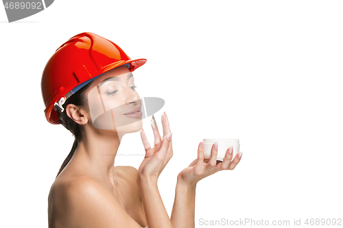 Image of Portrait of confident female worker in orange helmet