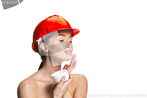 Image of Portrait of confident female worker in orange helmet