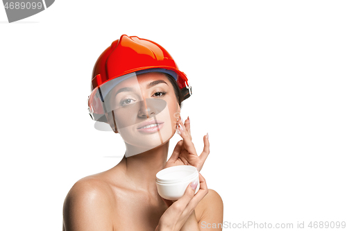 Image of Portrait of confident female worker in orange helmet