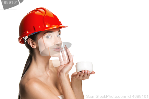 Image of Portrait of confident female worker in orange helmet