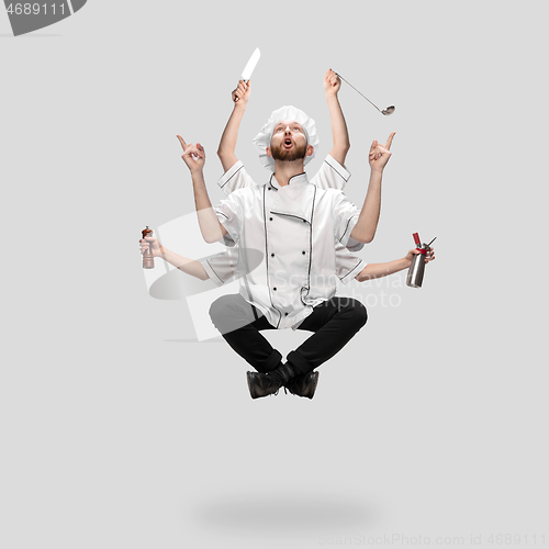 Image of Cooker, chef, baker in uniform multitask like shiva isolated on gray studio background