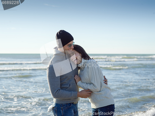 Image of Loving young couple on a beach at autumn sunny day