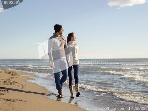 Image of Loving young couple on a beach at autumn sunny day