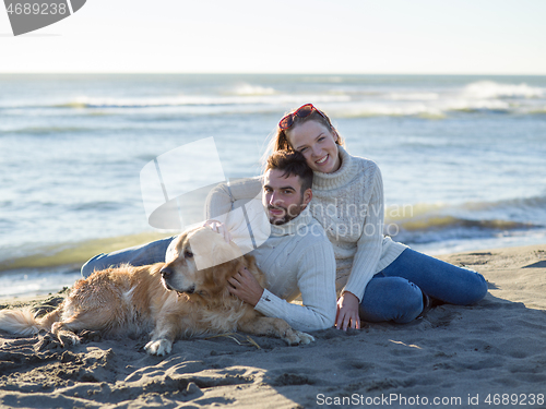 Image of Couple with dog enjoying time on beach