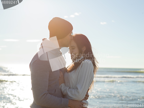 Image of Loving young couple on a beach at autumn sunny day