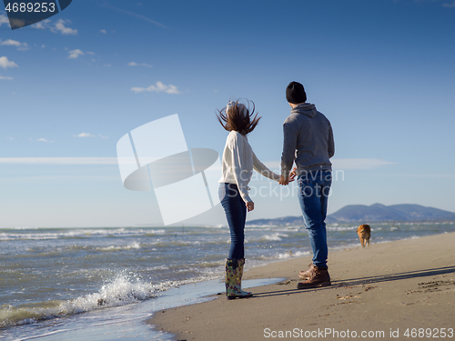 Image of Loving young couple on a beach at autumn sunny day