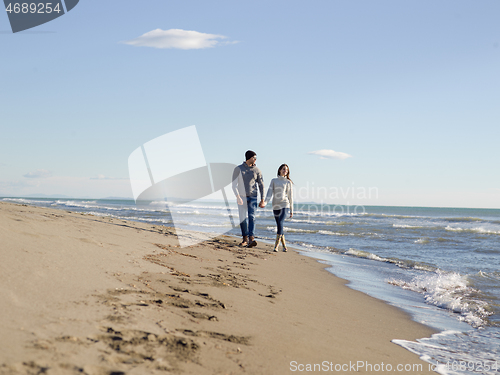 Image of Loving young couple on a beach at autumn sunny day