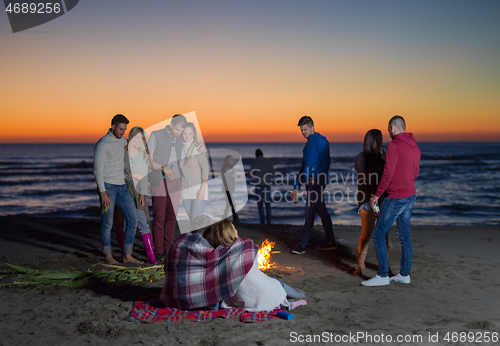 Image of Friends having fun at beach on autumn day