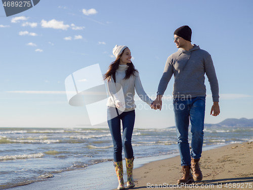 Image of Loving young couple on a beach at autumn sunny day