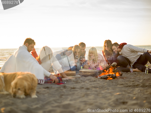 Image of Friends having fun at beach on autumn day