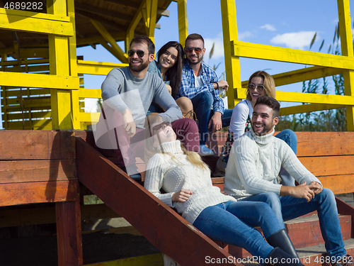 Image of Group of friends having fun on autumn day at beach