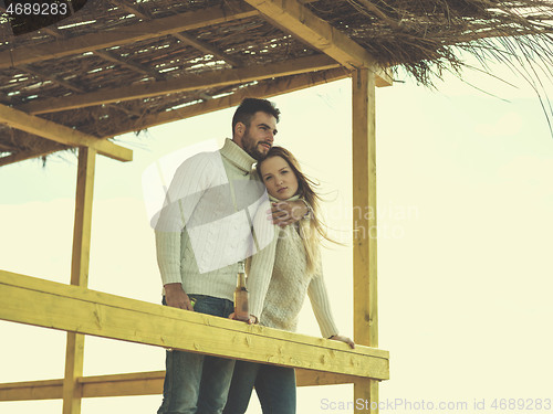 Image of young couple drinking beer together at the beach