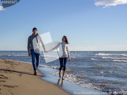 Image of Loving young couple on a beach at autumn sunny day