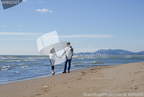 Image of Loving young couple on a beach at autumn sunny day