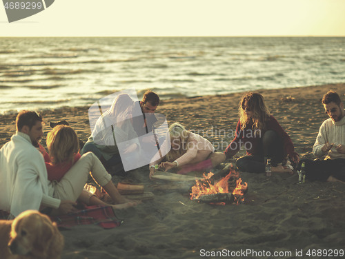 Image of Friends having fun at beach on autumn day