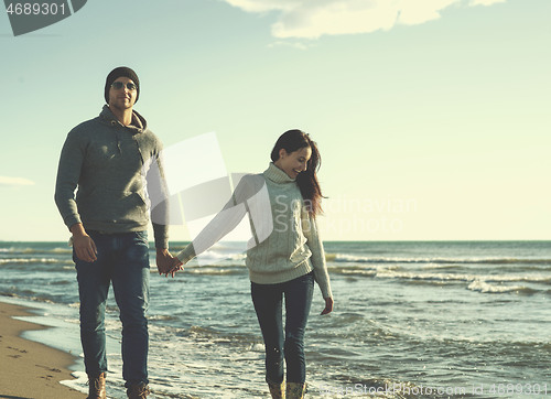 Image of Loving young couple on a beach at autumn sunny day