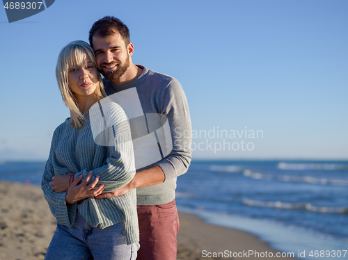 Image of Loving young couple on a beach at autumn sunny day