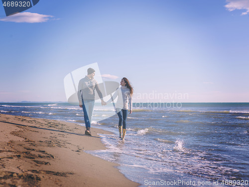 Image of Loving young couple on a beach at autumn sunny day