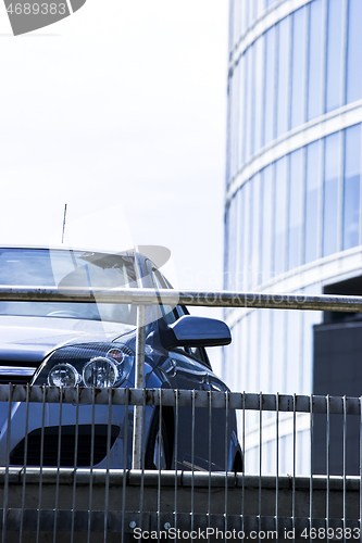 Image of Front view of car with skyscraper in background