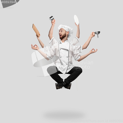 Image of Cooker, chef, baker in uniform multitask like shiva isolated on gray studio background