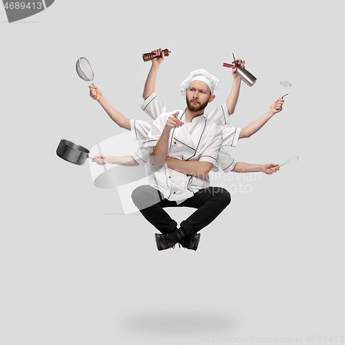 Image of Cooker, chef, baker in uniform multitask like shiva isolated on gray studio background