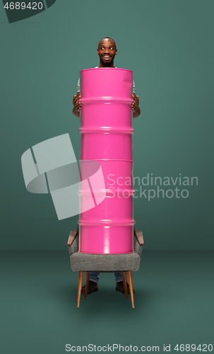 Image of Tall high man and long barrel isolated on green studio background. Unusual delighted and long