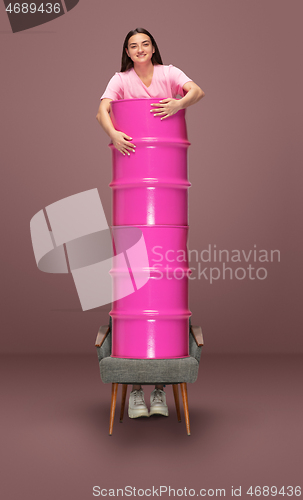 Image of Tall high woman and long barrel isolated on braun studio background. Unusual delighted and long