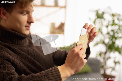 Image of Man opening, recieving greeting card for New Year and Christmas 2021 from friends or family