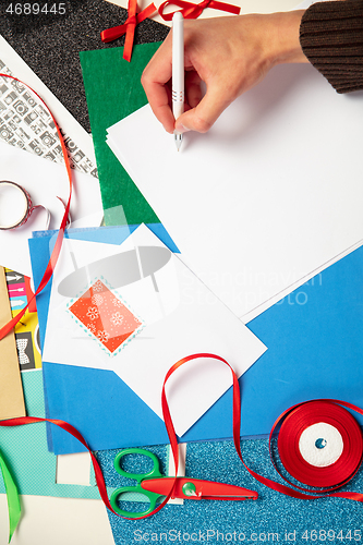 Image of Man making greeting card for New Year and Christmas 2021 for friends or family, scrap booking, DIY