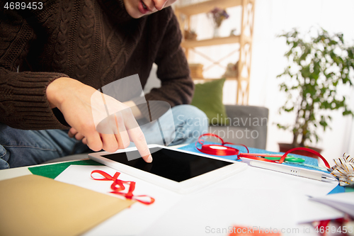 Image of Man reading message, greetings for New Year and Christmas 2021 from friends or family with his tablet