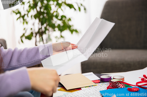 Image of Woman opening, recieving greeting card for New Year and Christmas 2021 from friends or family