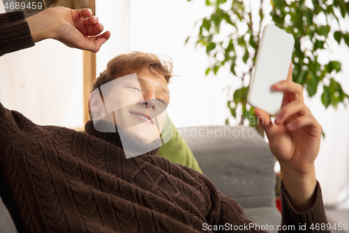 Image of Man reading message, greetings for New Year and Christmas 2021 from friends or family with his cellphone