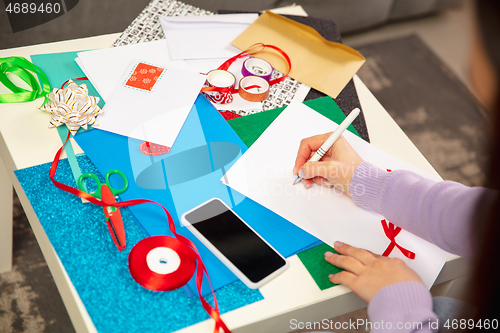 Image of Woman making greeting card for New Year and Christmas 2021 for friends or family, scrap booking, DIY