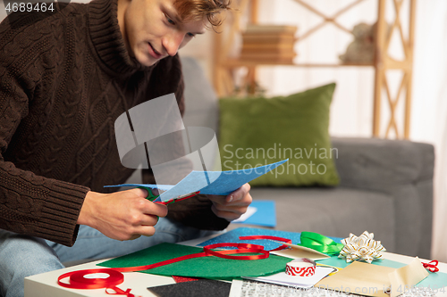 Image of Man making greeting card for New Year and Christmas 2021 for friends or family, scrap booking, DIY