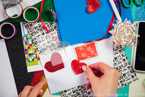 Image of Woman making greeting card for New Year and Christmas 2021 for friends or family, scrap booking, DIY